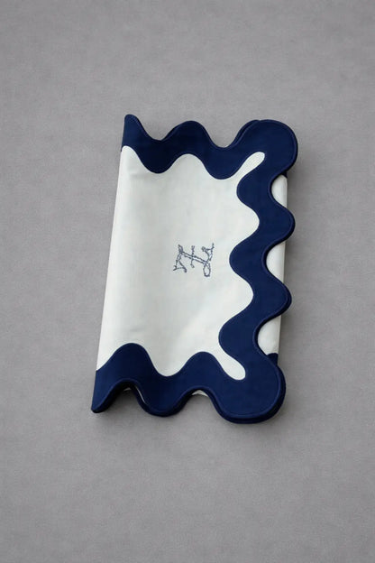 Chemin de table bleu brodé plié, détail de la finition ondulée